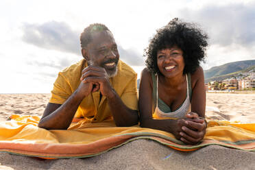 Beautiful mature black couple of lovers dating at the seaside - Married african middle-aged couple bonding and having fun outdoors, concepts about relationship, lifestyle and quality of life - DMDF10460