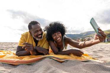 Beautiful mature black couple of lovers dating at the seaside - Married african middle-aged couple bonding and having fun outdoors, concepts about relationship, lifestyle and quality of life - DMDF10462