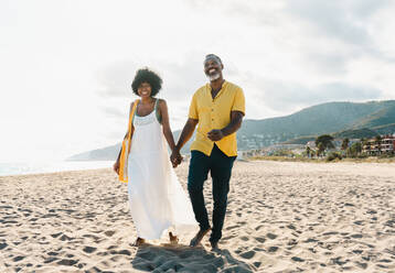 Beautiful mature black couple of lovers dating at the seaside - Married african middle-aged couple bonding and having fun outdoors, concepts about relationship, lifestyle and quality of life - DMDF10475