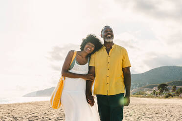 Beautiful mature black couple of lovers dating at the seaside - Married african middle-aged couple bonding and having fun outdoors, concepts about relationship, lifestyle and quality of life - DMDF10484