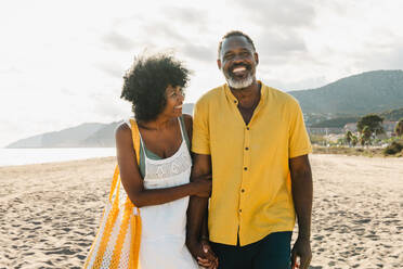 Beautiful mature black couple of lovers dating at the seaside - Married african middle-aged couple bonding and having fun outdoors, concepts about relationship, lifestyle and quality of life - DMDF10487