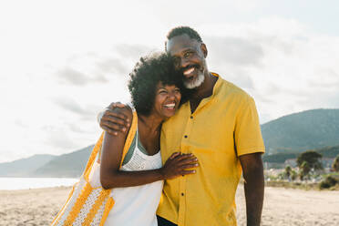 Beautiful mature black couple of lovers dating at the seaside - Married african middle-aged couple bonding and having fun outdoors, concepts about relationship, lifestyle and quality of life - DMDF10489