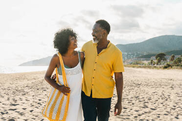 Beautiful mature black couple of lovers dating at the seaside - Married african middle-aged couple bonding and having fun outdoors, concepts about relationship, lifestyle and quality of life - DMDF10490