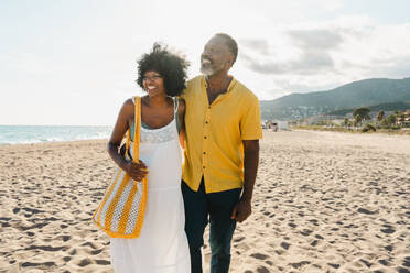 Beautiful mature black couple of lovers dating at the seaside - Married african middle-aged couple bonding and having fun outdoors, concepts about relationship, lifestyle and quality of life - DMDF10493