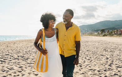 Beautiful mature black couple of lovers dating at the seaside - Married african middle-aged couple bonding and having fun outdoors, concepts about relationship, lifestyle and quality of life - DMDF10494