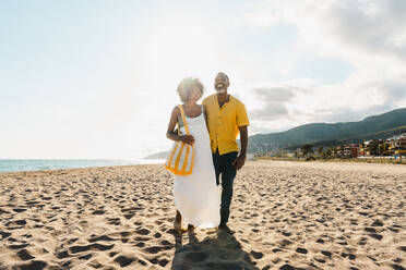 Beautiful mature black couple of lovers dating at the seaside - Married african middle-aged couple bonding and having fun outdoors, concepts about relationship, lifestyle and quality of life - DMDF10495