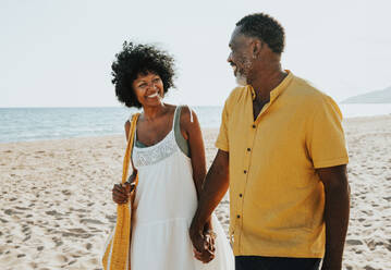 Beautiful mature black couple of lovers dating at the seaside - Married african middle-aged couple bonding and having fun outdoors, concepts about relationship, lifestyle and quality of life - DMDF10496