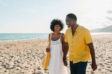 Beautiful mature black couple of lovers dating at the seaside - Married african middle-aged couple bonding and having fun outdoors, concepts about relationship, lifestyle and quality of life - DMDF10497