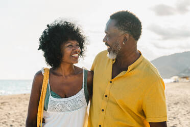Beautiful mature black couple of lovers dating at the seaside - Married african middle-aged couple bonding and having fun outdoors, concepts about relationship, lifestyle and quality of life - DMDF10499