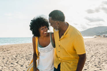 Beautiful mature black couple of lovers dating at the seaside - Married african middle-aged couple bonding and having fun outdoors, concepts about relationship, lifestyle and quality of life - DMDF10500