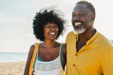 Beautiful mature black couple of lovers dating at the seaside - Married african middle-aged couple bonding and having fun outdoors, concepts about relationship, lifestyle and quality of life - DMDF10501