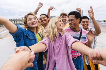 Happy young friends holding hands and having fun together - OIPF04033