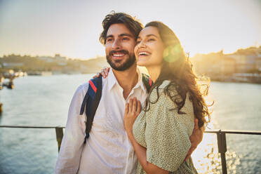 Smiling couple in front of Douro river at Porto, Portugal - BSZF02698