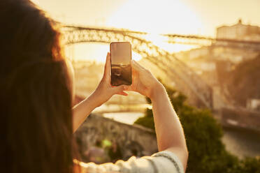 Frau fotografiert die Dom-Luis-Brücke in Porto, Portugal, mit ihrem Smartphone - BSZF02702