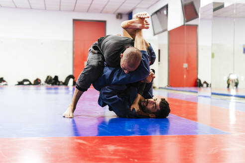 Sportler üben Jiu-Jitsu im Dojo - PBTF00497