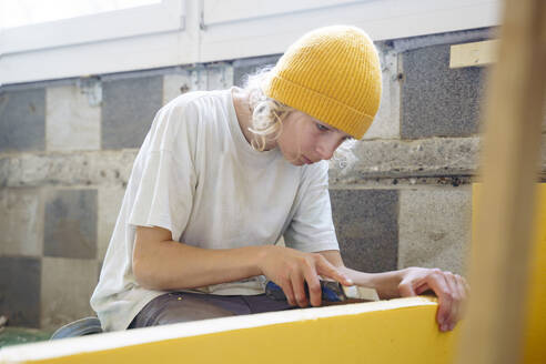 Boy cutting insulation at home - NJAF00805