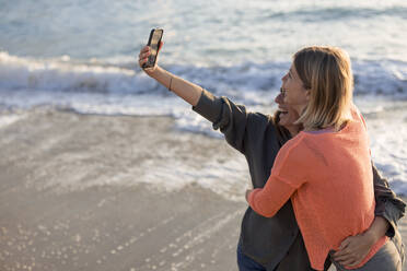 Glückliche Freunde mit ausgestreckten Armen machen ein Selfie am Strand am Wochenende - JOSEF23667