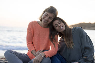 Lächelnde Freunde entspannen zusammen am Strand - JOSEF23671