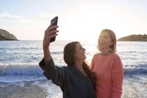 Fröhliche Freunde, die zusammen ein Selfie am Strand machen - JOSEF23713