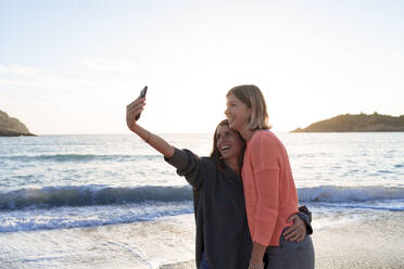 Carefree friends taking selfie together on shore at beach - JOSEF23715