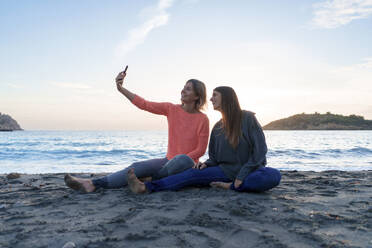 Fröhliche Freunde nehmen Selfie zusammen am Ufer bei Sonnenuntergang Strand - JOSEF23723