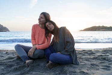 Lächelnde Freunde, die sich gemeinsam am Strand entspannen - JOSEF23724