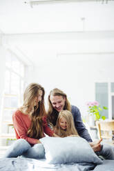 Glücklicher Vater und Mutter spielen mit ihrer Tochter zu Hause - JOSEF23734