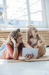 Happy mother and daughter with tablet PC at home - JOSEF23746