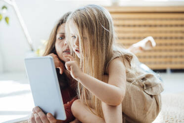 Girl using tablet PC with mother at home - JOSEF23749