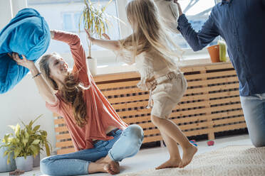 Happy family playing pillow fight at home - JOSEF23753