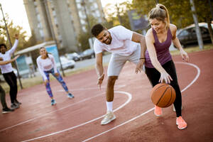 Group of multiethnic young people playing basketball on court - INGF13007