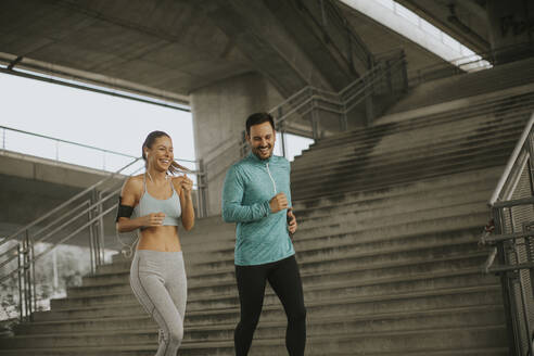 Young couple running in the urban enviroment - INGF13014