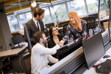 Young business people shaking hands in the modern office - INGF13052
