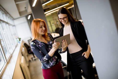Creative young female executives using digital tablet in office - INGF13058