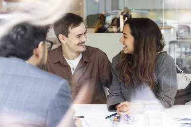 Smiling couple meeting with real estate agent in office - MASF43143