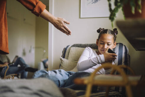 Daughter ignoring father while using mobile phone at home - MASF43186