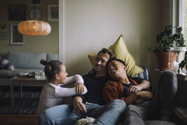 Daughter talking to gay parents sitting at home - MASF43221