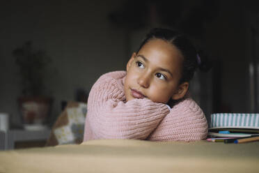 Girl resting head on arms and day dreaming at home - MASF43234