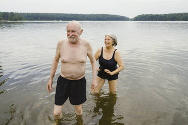 Happy senior couple enjoying at riverbank - MASF43421