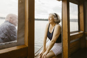 Happy senior woman sitting with man at houseboat - MASF43447