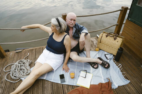 High angle view of senior couple sitting together on houseboat - MASF43450