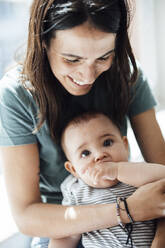 Smiling mother with baby girl at home - JOSEF23858