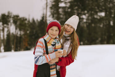 Happy mother and son wearing warm clothes in winter forest - MCHF00011