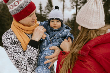 Niedlicher kleiner Junge mit Eltern im Winterwald - MCHF00020