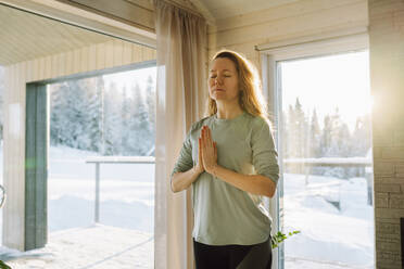 Frau mit geschlossenen Augen im Gebet Yoga-Pose zu Hause stehen - OLRF00207