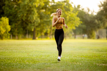 Pretty young woman running in park - INGF13119