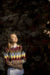 Pretty young woman standing outside at sunny autumn day - INGF13152