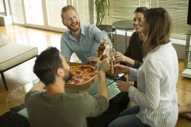 Group of happy young people eating pizza and drinking cider in the modern interior - INGF13156