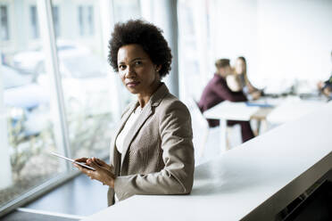 Successful black Afro American business woman working with digital tablet at the modern office - INGF13171