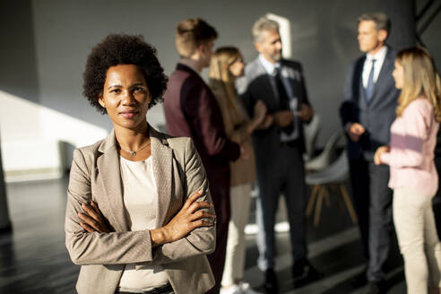African American business woman standing in front of her team in the office - INGF13177